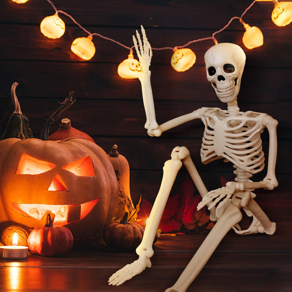 Posable skeleton decoration sitting next to a carved pumpkin and Halloween lights