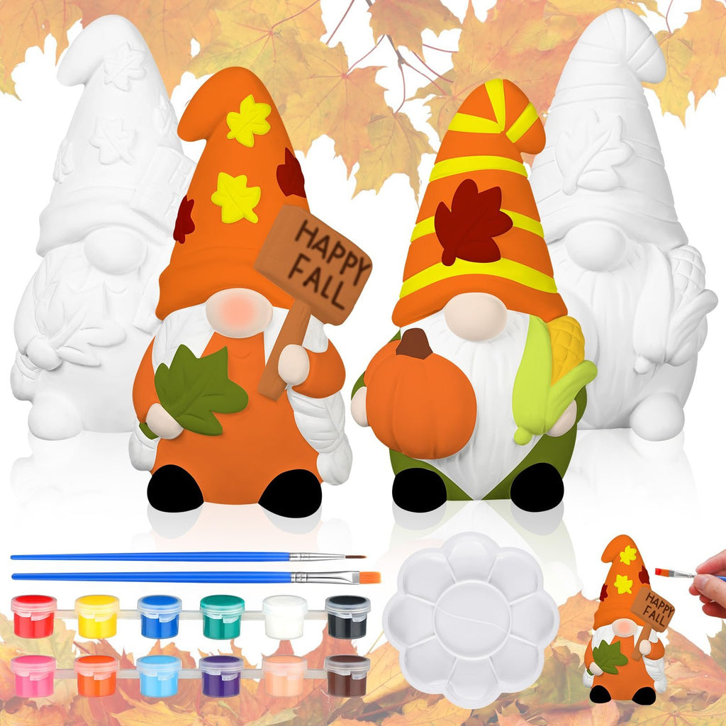 Two ceramic gnome statues, one painted orange with a pumpkin and corn, the other unpainted, with paint pots, brushes, and a palette.