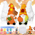 Two ceramic gnome statues, one painted orange with a pumpkin and corn, the other unpainted, with paint pots, brushes, and a palette.