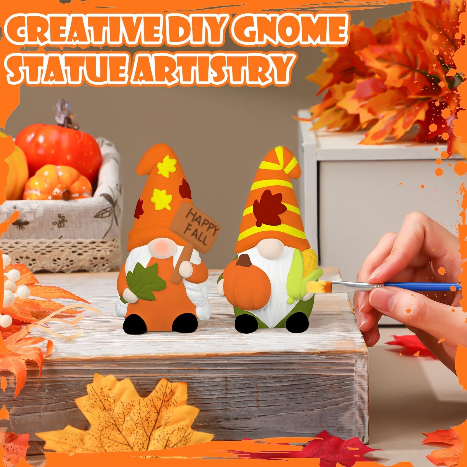 Two ceramic gnome statues, one holding a 'Happy Fall' sign, being painted by a hand with a brush.