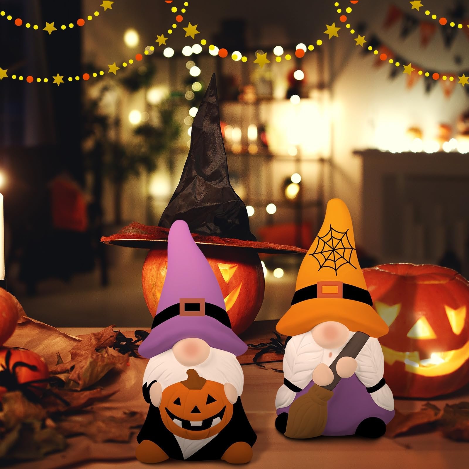 Two Halloween gnomes, one holding a pumpkin and the other a broom, with carved pumpkins and festive lights in the background.