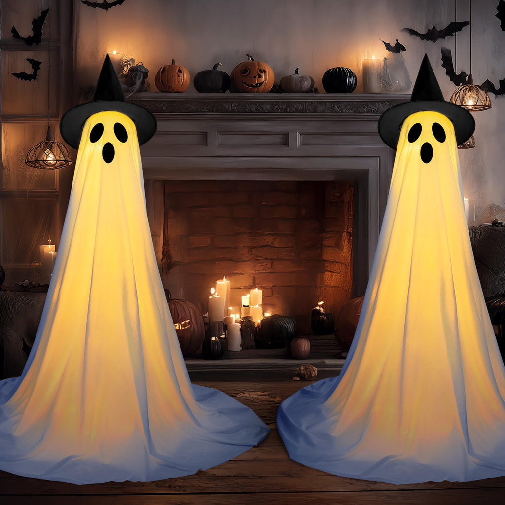 Two illuminated standing ghost decorations with witch hats in a Halloween-themed room with a fireplace.