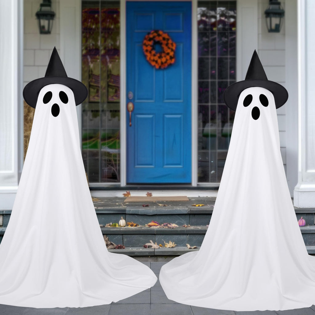 Two standing ghost Halloween decorations with witch hats on a porch with a blue door and wreath