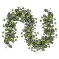 Faux eucalyptus garland with silver dollar leaves and white flowers on a white background