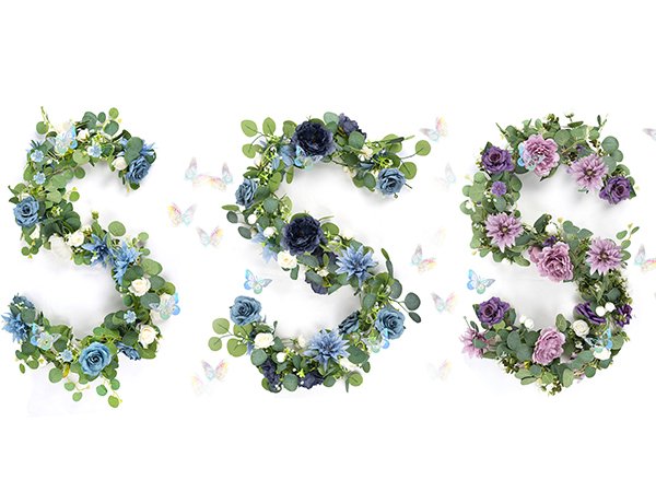 Three artificial eucalyptus garlands with navy blue and purple flowers and silver butterflies on a white background.