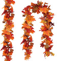 Two strands of artificial maple leaf garland in autumn colors against a white background.