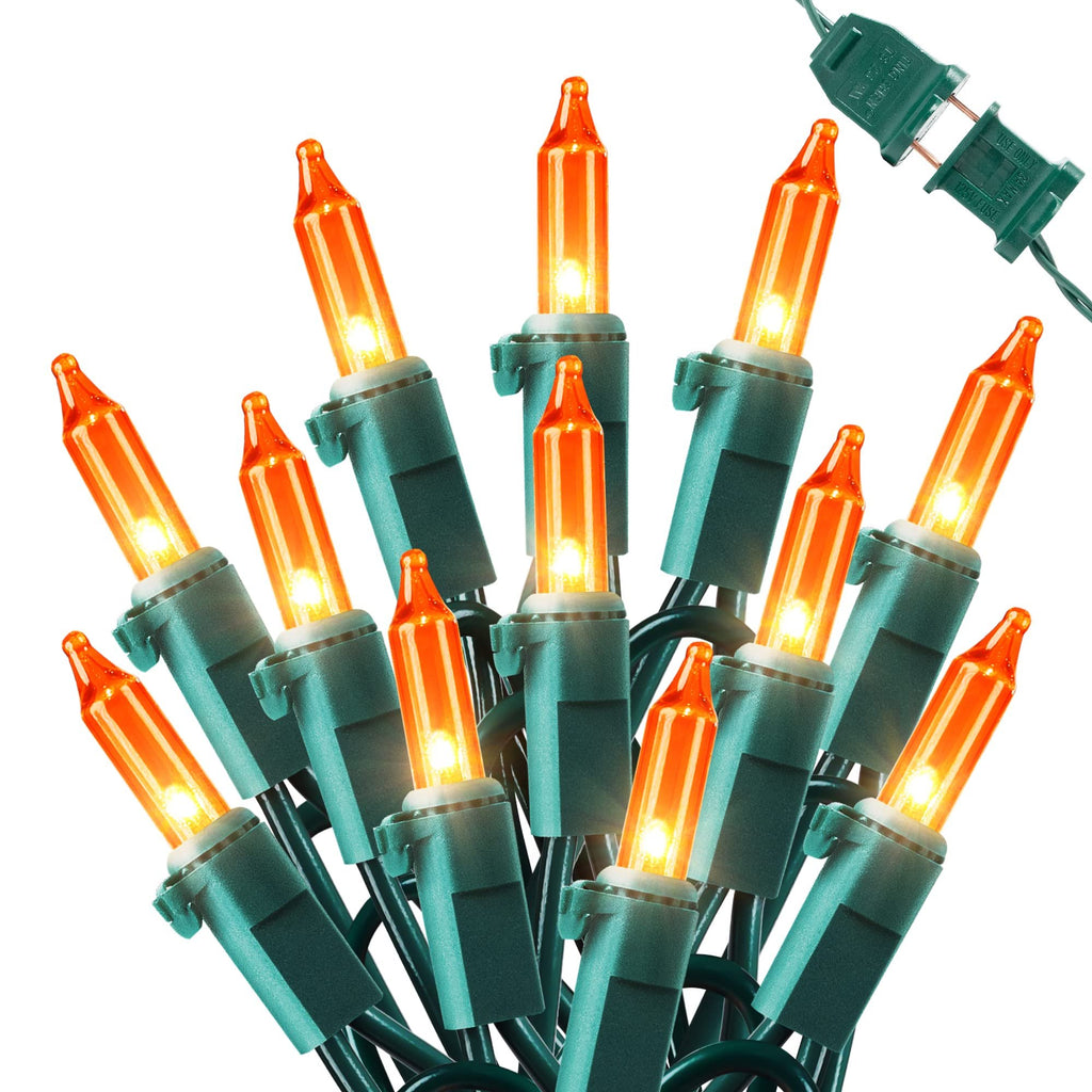 Cluster of orange mini string lights with green wire and plug on a white background