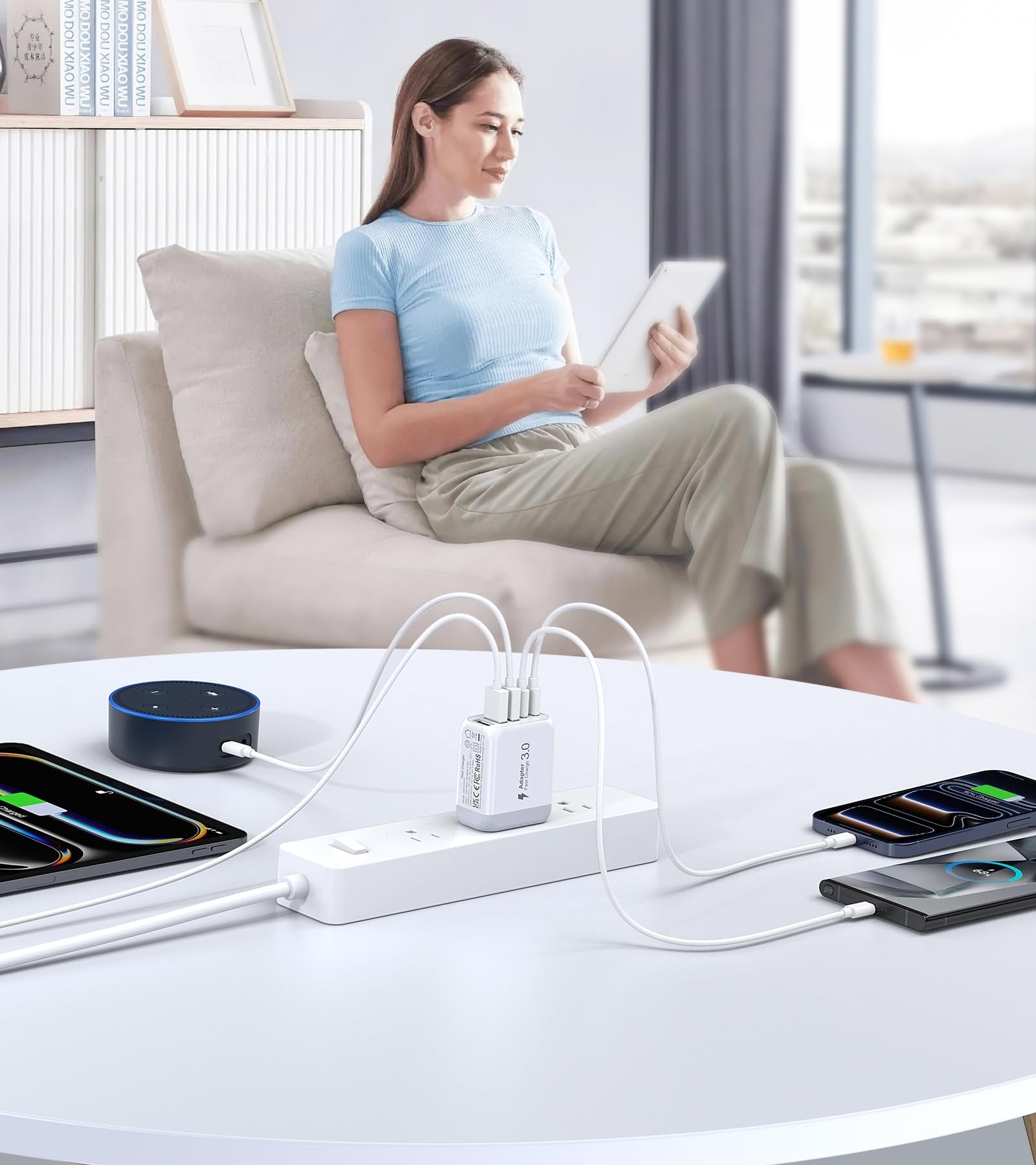 Woman using tablet while charging multiple devices with a 5-port USB wall charger