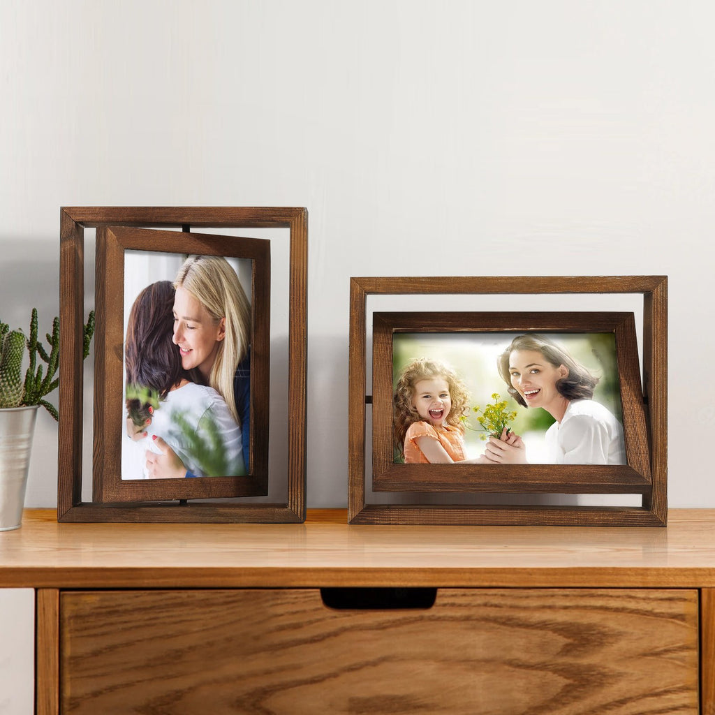 Two distressed wood rotating picture frames displaying photos of families on a wooden surface with a cactus in a pot.