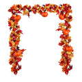 Autumn garland with fabric maple leaves in red, orange, and yellow, and small orange pumpkins, arranged in an arch shape.