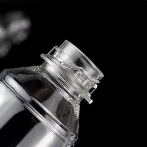Close-up of the neck and cap of a clear plastic continuous mist spray bottle against a black background.