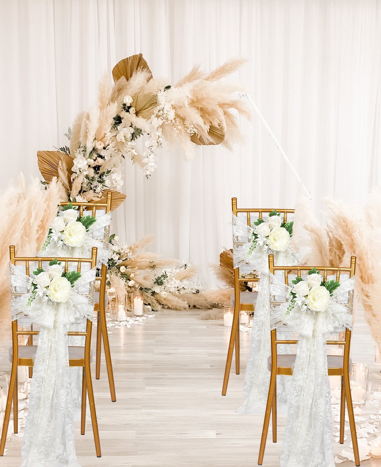 Wedding ceremony aisle with gold chairs decorated with white floral sashes and a pampas grass arch in the background.