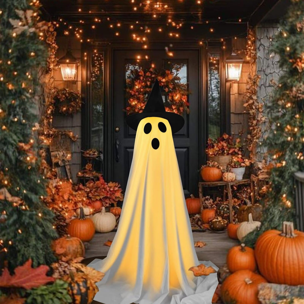 Halloween ghost decoration with witch hat on a porch with pumpkins and string lights