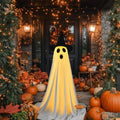 Halloween ghost decoration with witch hat on a porch with pumpkins and string lights