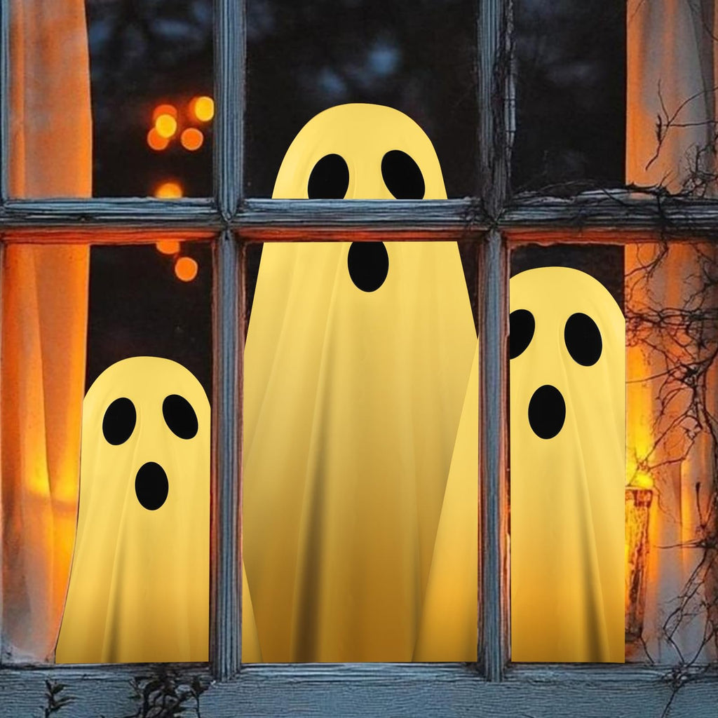 Three yellow ghost decorations with black eyes and mouths peeking through a rustic window at night with bokeh lights