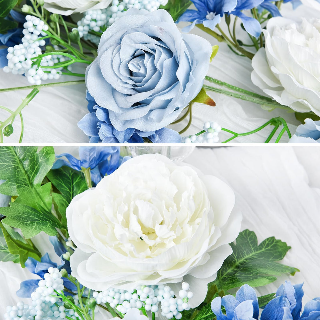 Close-up of artificial silk peony garland with blue and white flowers and green leaves on white fabric
