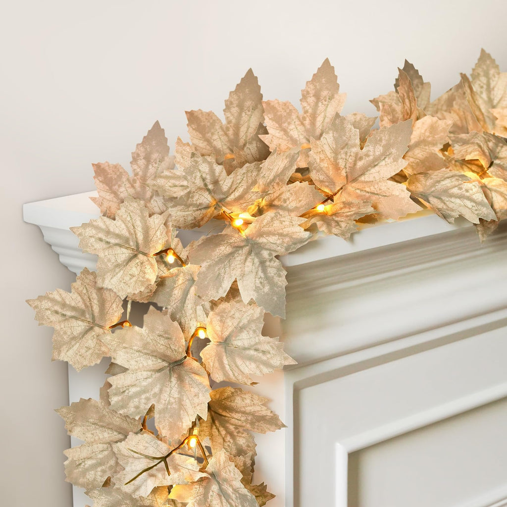 Autumn maple leaf garland with warm white LED lights draped over a white mantelpiece