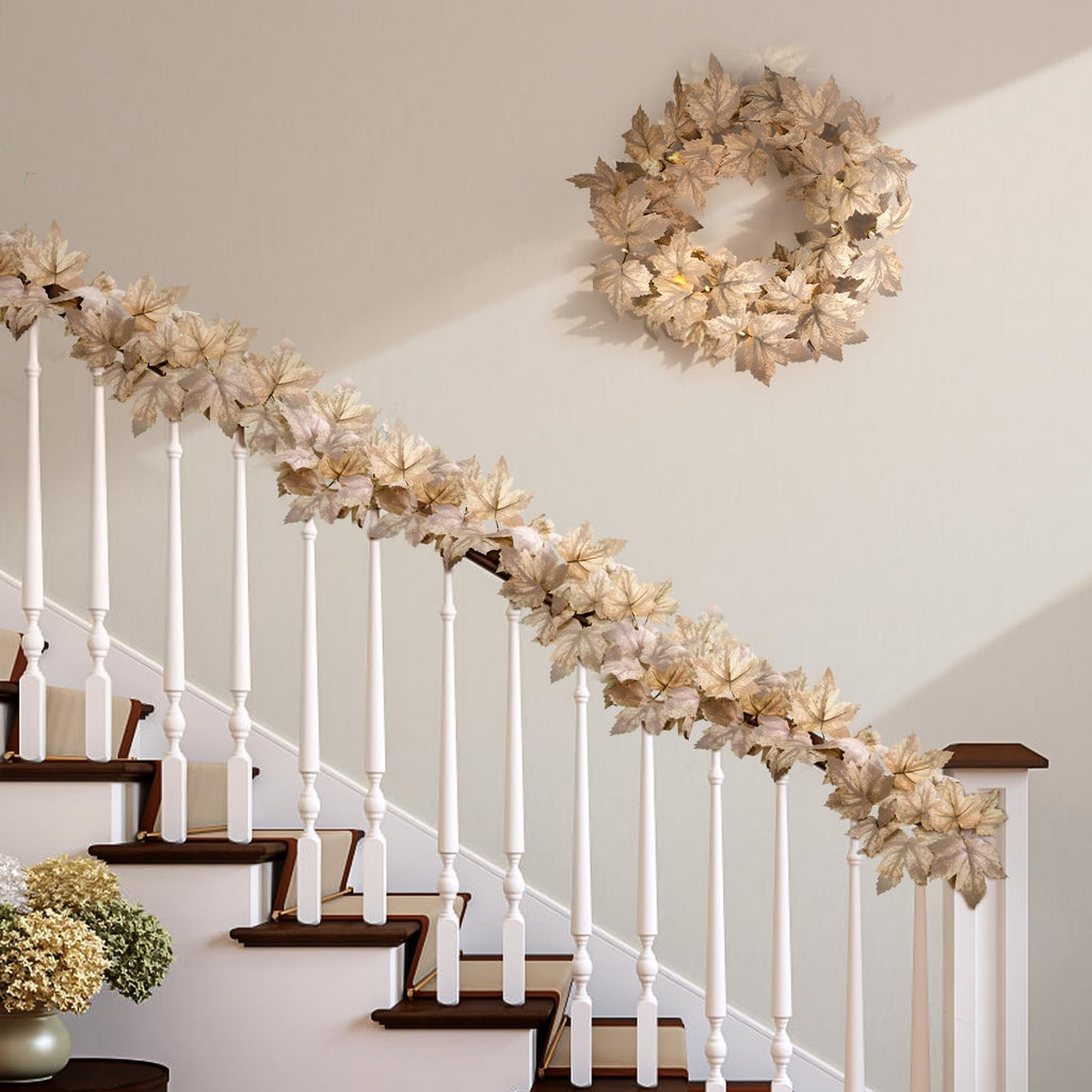 Lighted fall maple leaf garland draped on a staircase railing with a matching wreath on the wall.