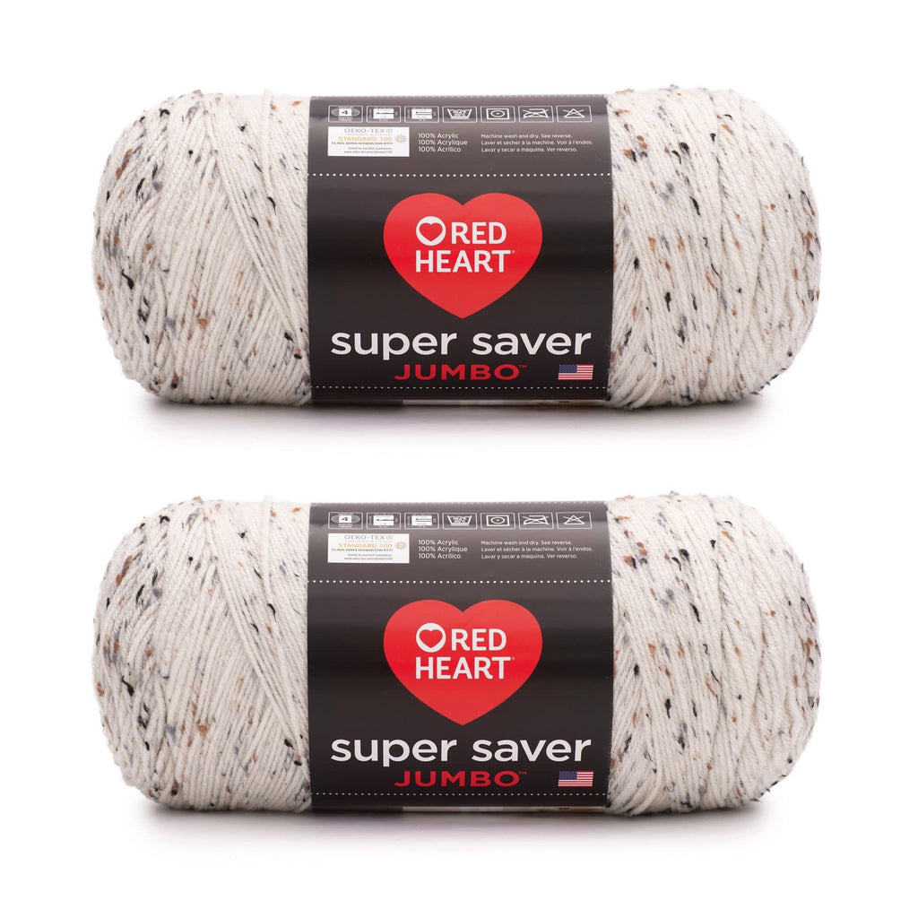 Two skeins of speckled white acrylic yarn with black, brown, and grey flecks, each with a black label showing care instructions and brand name.