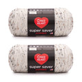 Two skeins of speckled white acrylic yarn with black, brown, and grey flecks, each with a black label showing care instructions and brand name.