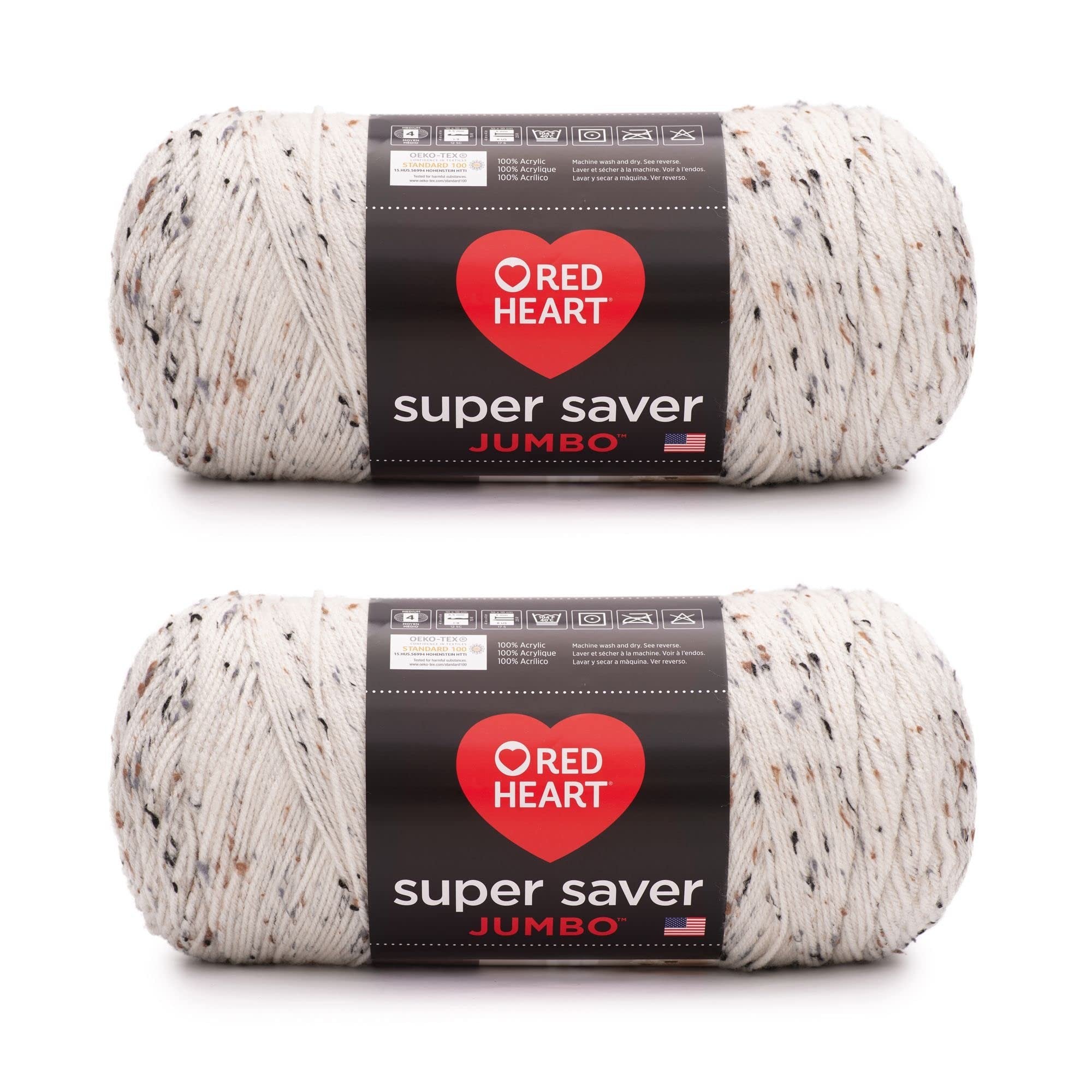 Two skeins of speckled white acrylic yarn with black, brown, and grey flecks, each with a black label showing care instructions and brand name.