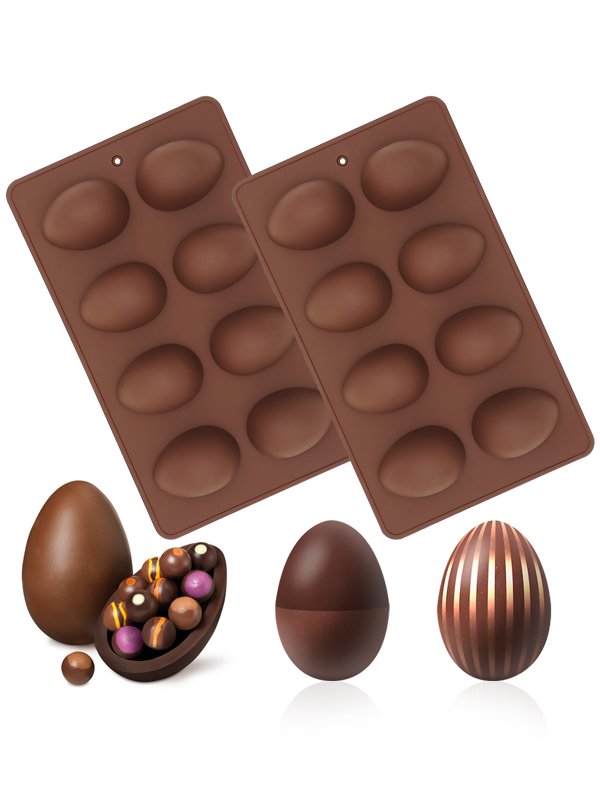 Two brown silicone Easter egg molds with chocolate eggs and candies displayed in front on a white background.