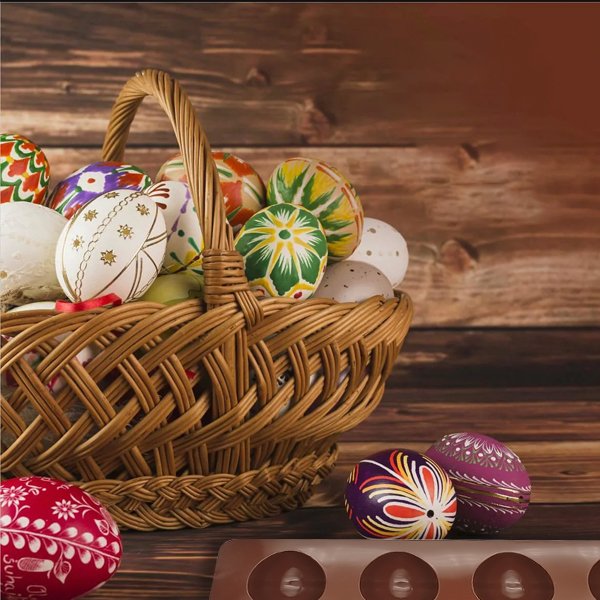 Easter eggs in a woven basket with a chocolate mold on a wooden surface