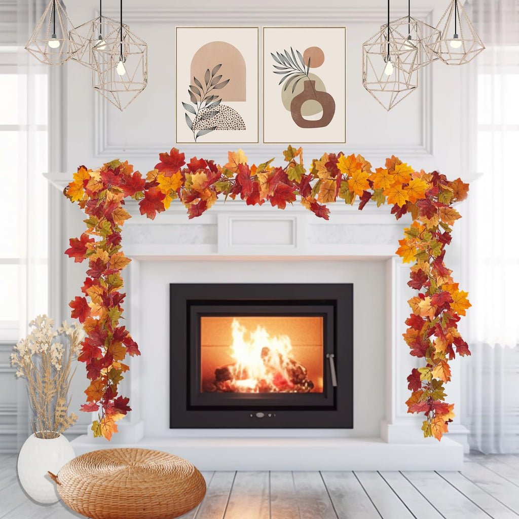 Artificial maple leaf garland draped over a fireplace with a fire burning inside.