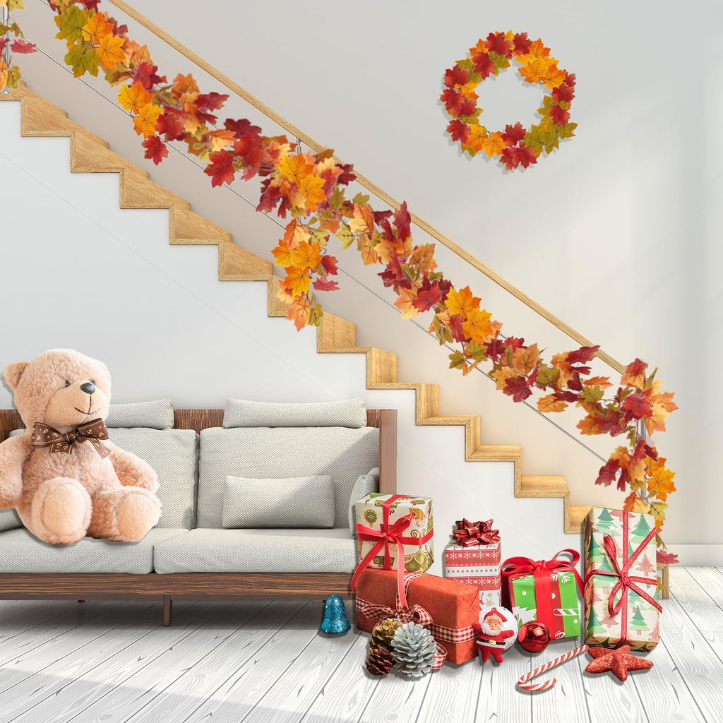 Autumn maple leaf garland draped on a staircase railing with a wreath on the wall and gifts below