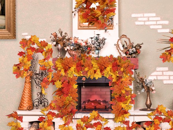 Autumn maple leaf garland draped around a fireplace mantel with decorative vases and floral arrangements.