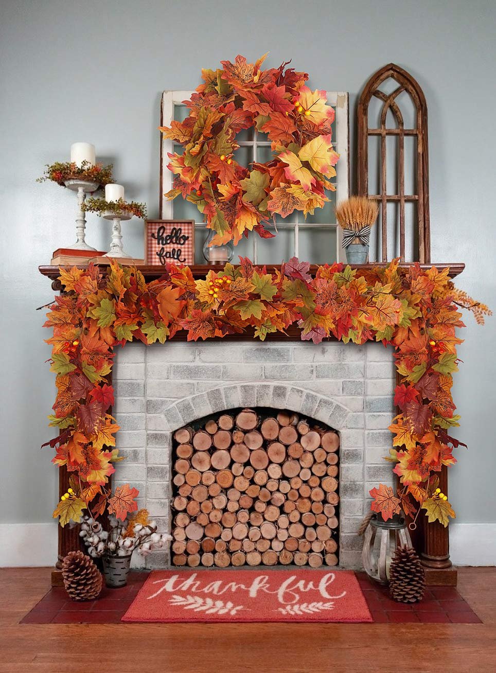 Autumn maple leaf garland and wreath decorating a fireplace mantle with a 'hello fall' sign and 'thankful' doormat.