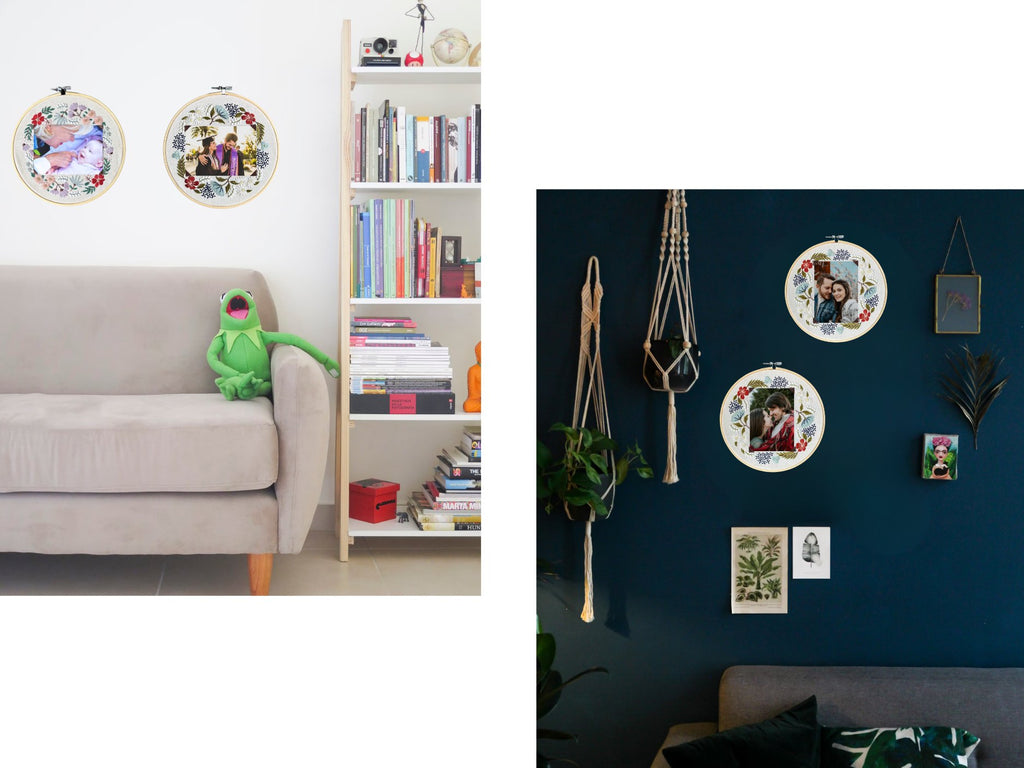 Two floral embroidery photo frames hanging on a wall, one with a baby and hands, the other with a couple.