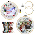 Two floral embroidery photo frame kits with bamboo hoops, embroidery floss, needles, and scissors on a white background.