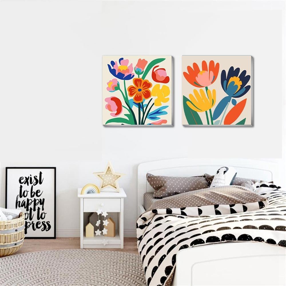Two framed floral paint by number canvases hanging above a bed with a nightstand.