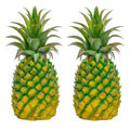 Two artificial green pineapples with textured yellow and green bodies and spiky green leaves, isolated on a white background.