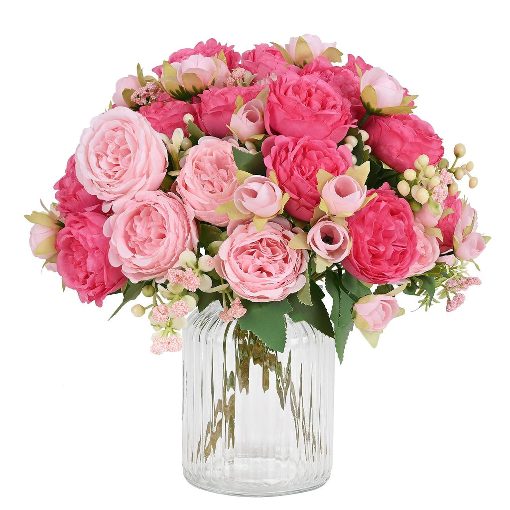 Mixed pink silk peonies in a clear glass vase, front view. Bouquet features large peony blooms and smaller buds.