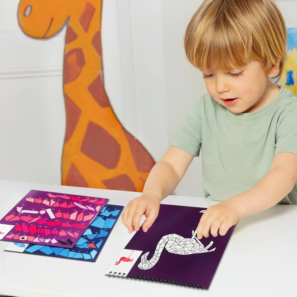 Young boy doing a paint by number sticker book activity with animal and ocean pictures.