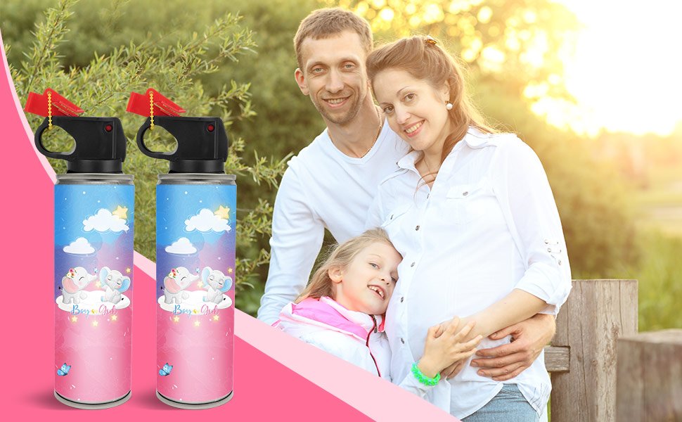 Family posing with two pink gender reveal smoke bombs in foreground, outdoor setting