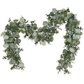Artificial eucalyptus garland with silver dollar leaves on a white background, draped in a wavy shape.