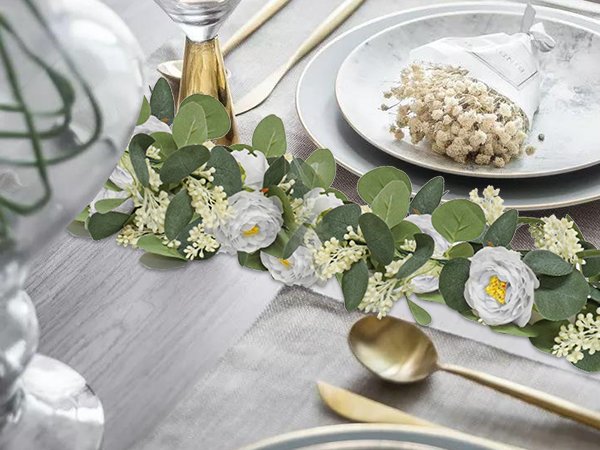 Artificial eucalyptus garland with white roses and baby's breath on a table setting