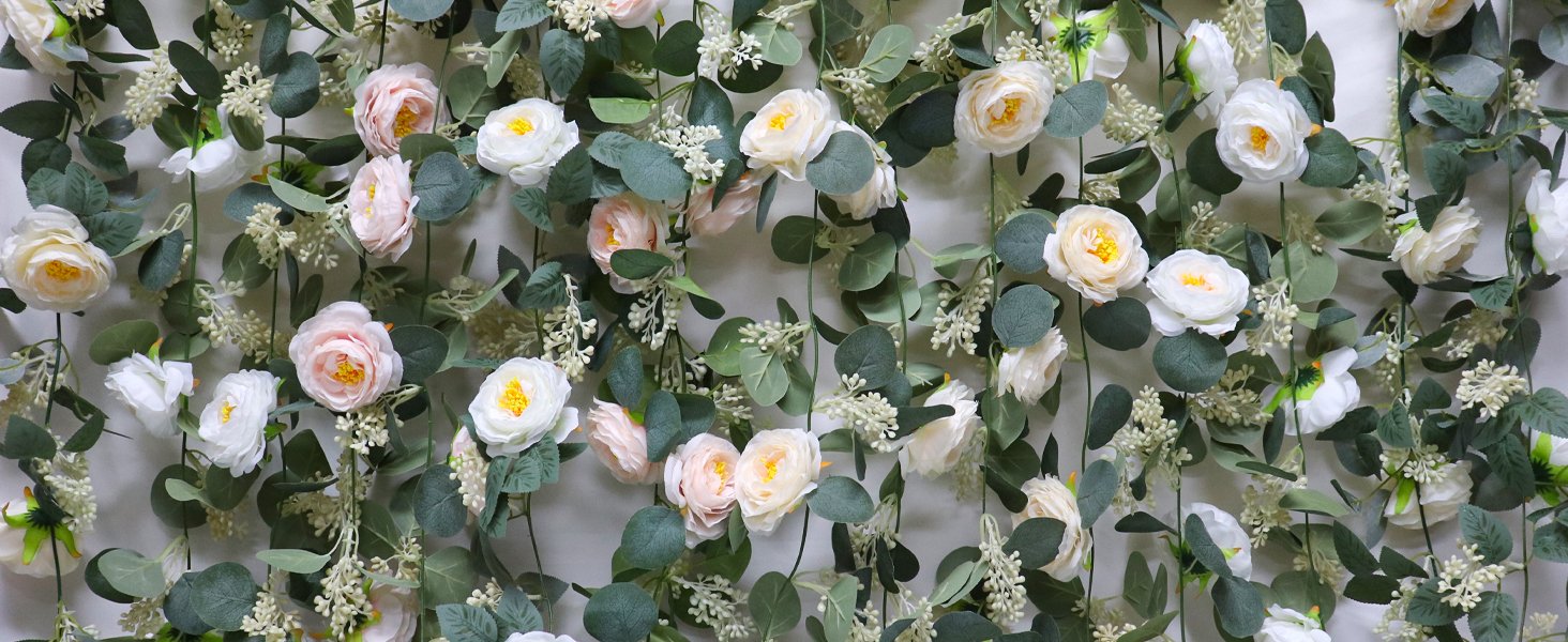 Artificial eucalyptus garland with pink and white roses and seeded leaves against a white background.