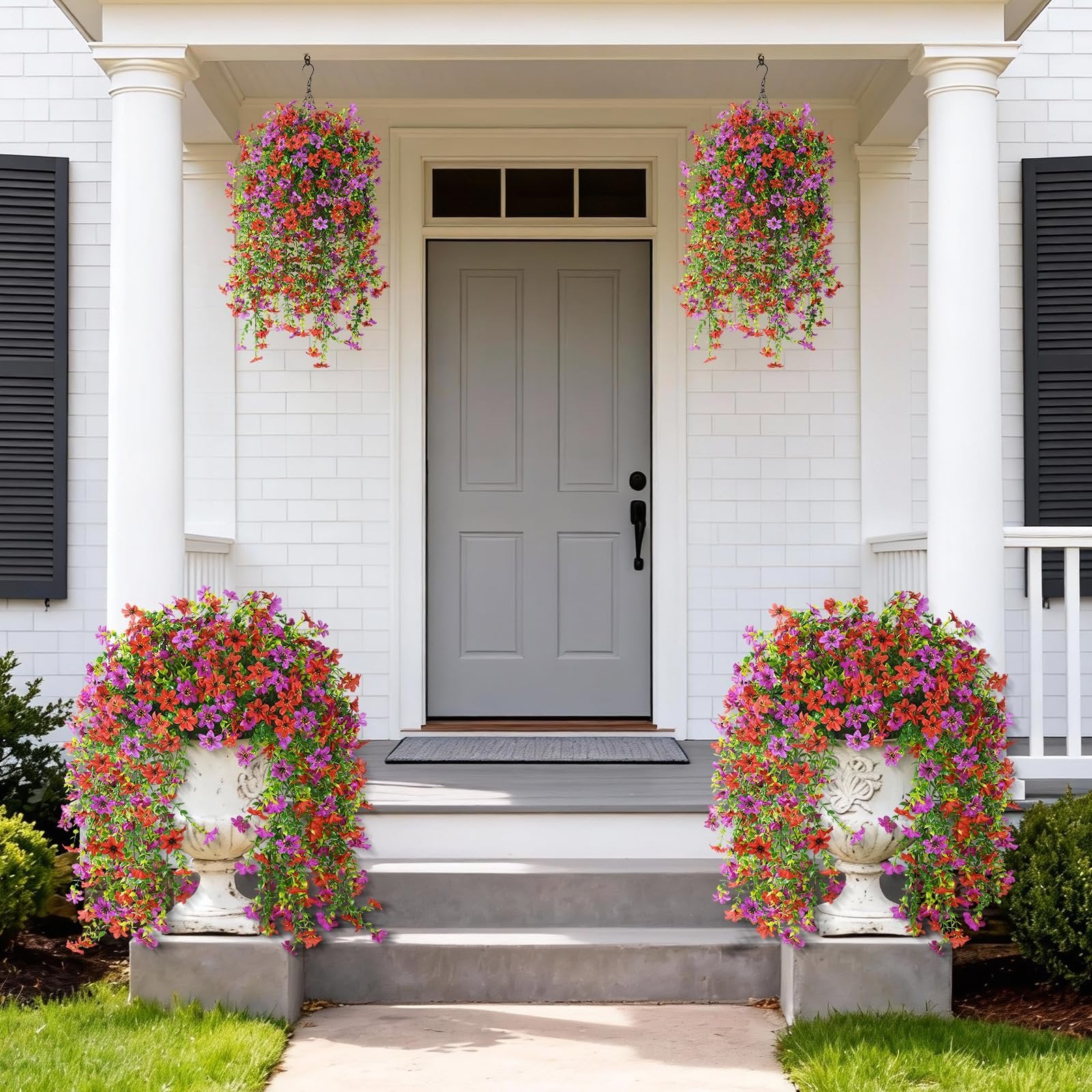 Two hanging baskets and two urns filled with red and purple artificial flowers adorn a porch entrance.