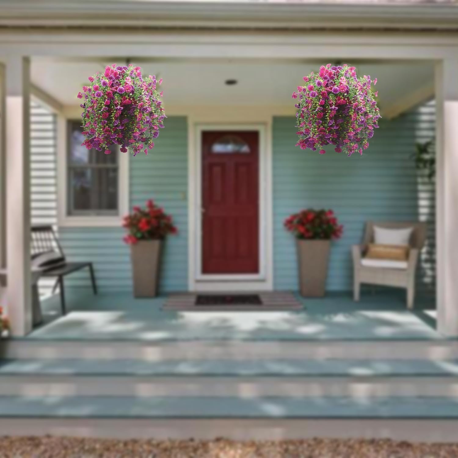 Two hanging baskets of purple and pink artificial morning glory flowers on a porch.