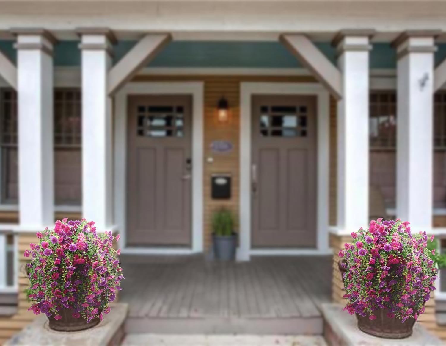 Two hanging baskets of purple and fuchsia artificial morning glory flowers on a porch.