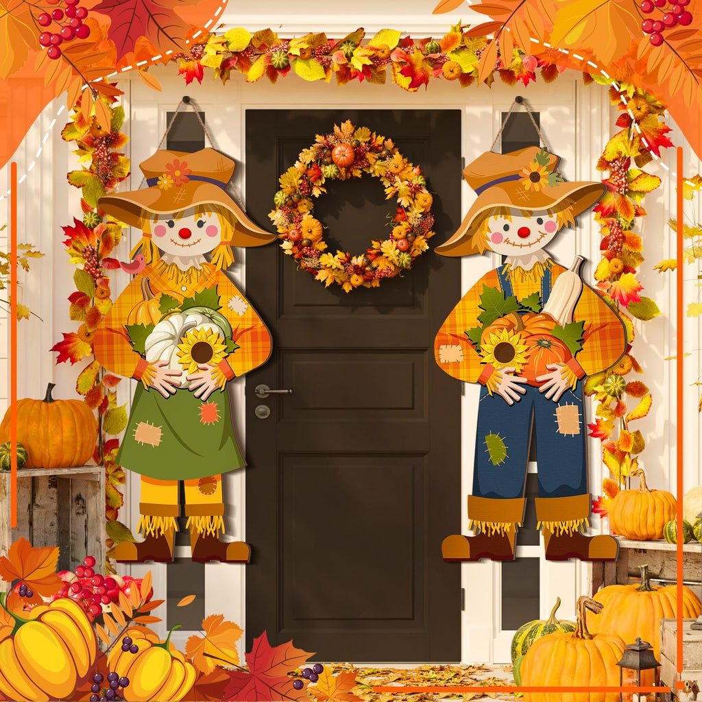 Two scarecrow door decorations and a fall wreath hang on a dark front door with autumn leaves and pumpkins decorating the porch.
