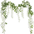 Two strands of artificial white wisteria garland with green leaves against a white background