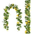 Two artificial lemon vine garlands with green leaves, white flowers, and yellow lemons against a white background.