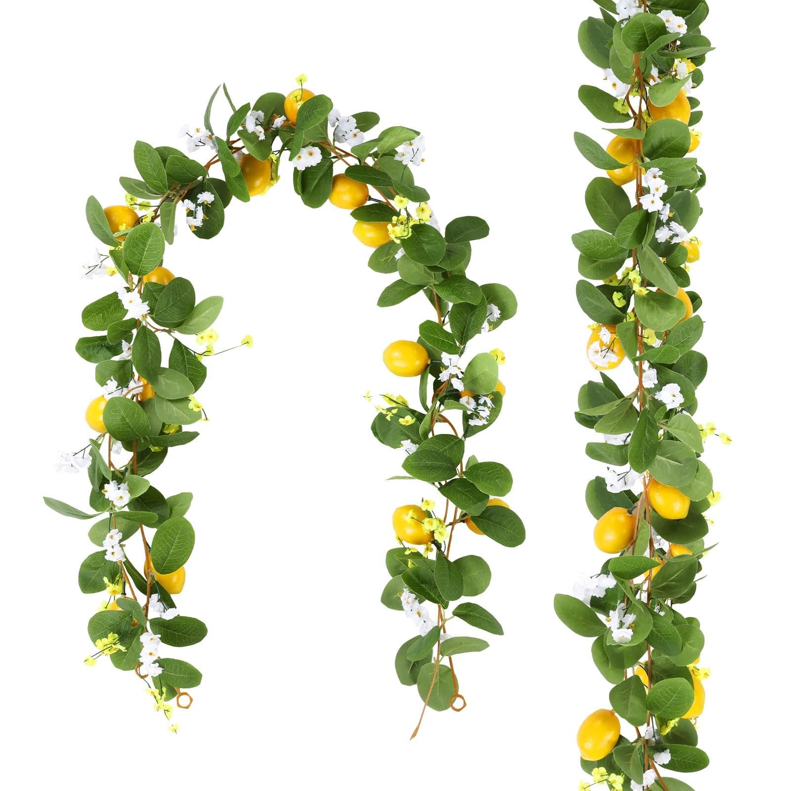 Two artificial lemon vine garlands with green leaves, white flowers, and yellow lemons against a white background.