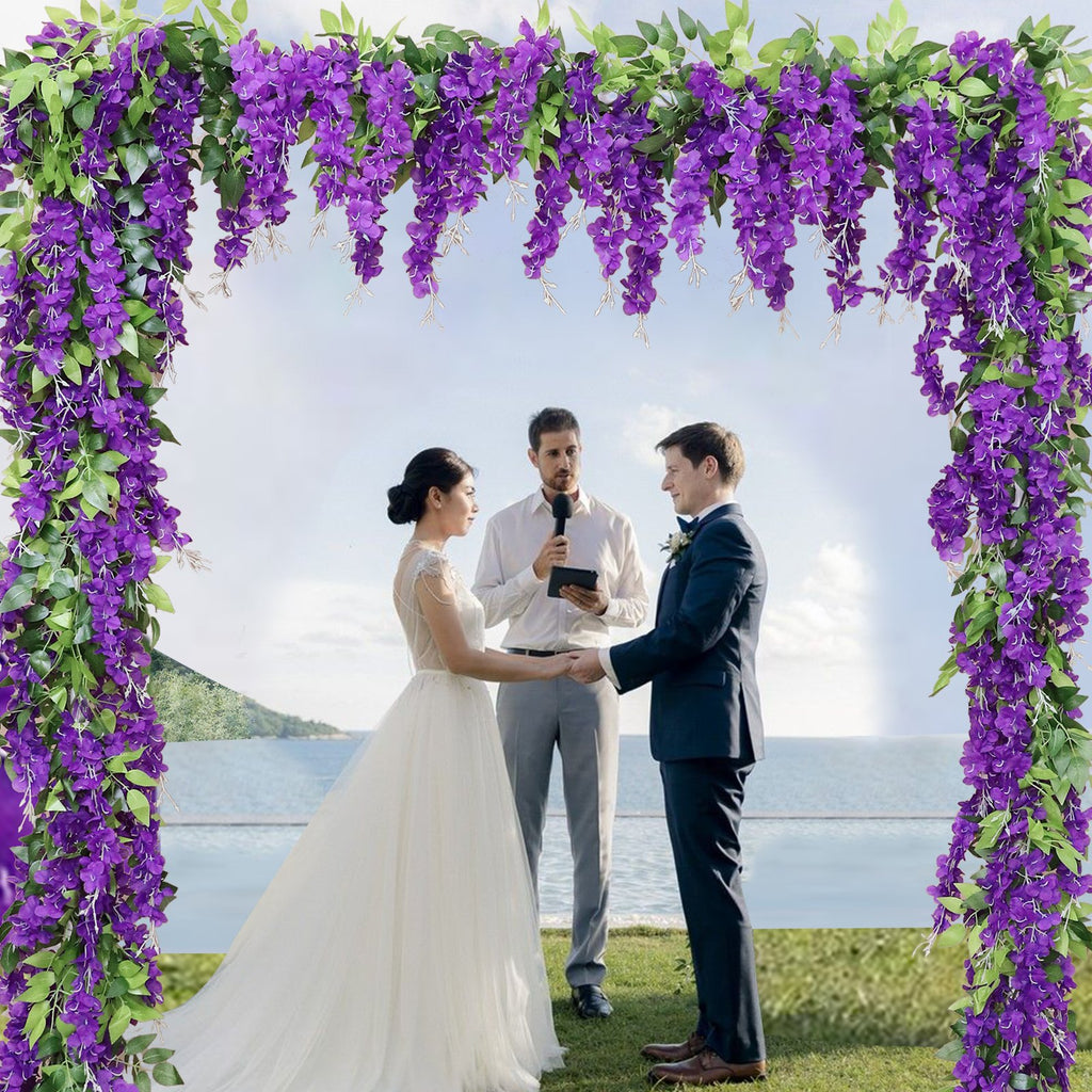 Wedding ceremony with purple wisteria garland arch, bride, groom, and officiant by the ocean