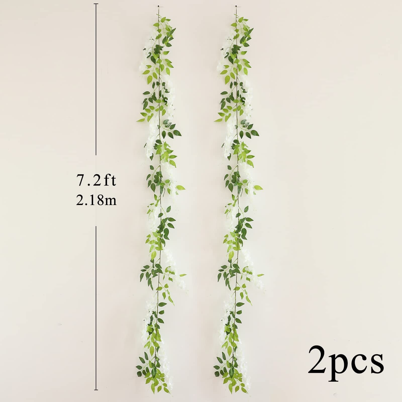 Two white faux wisteria garlands with green leaves hanging vertically against a cream wall, with size and quantity indicators.